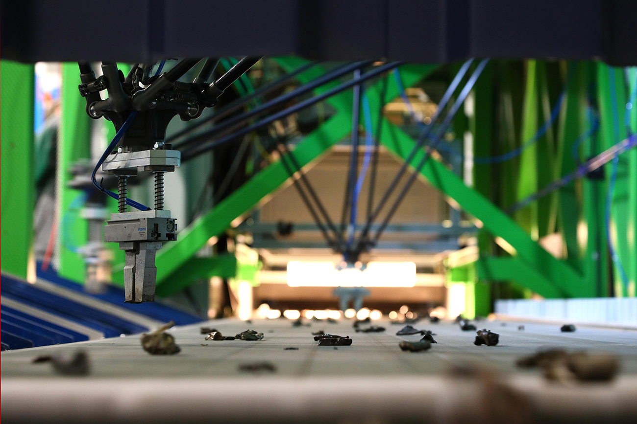 Robot gripper extracting a piece from a moving conveyor