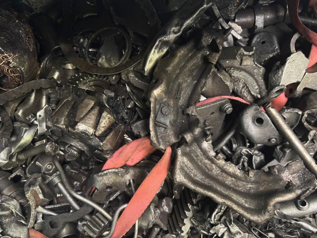 Mixed shredded scrap where steel, non-ferrous pieces and rubber straps lie side by side