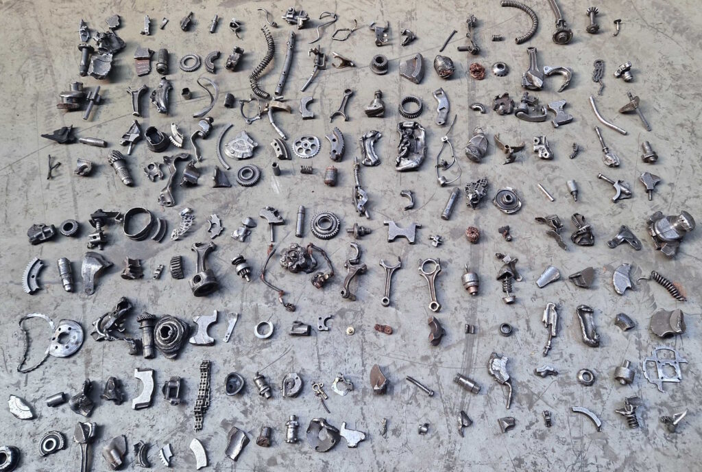 Metal scrap pieces laid out one by one on the floor, sorted by class before sensor acquisition